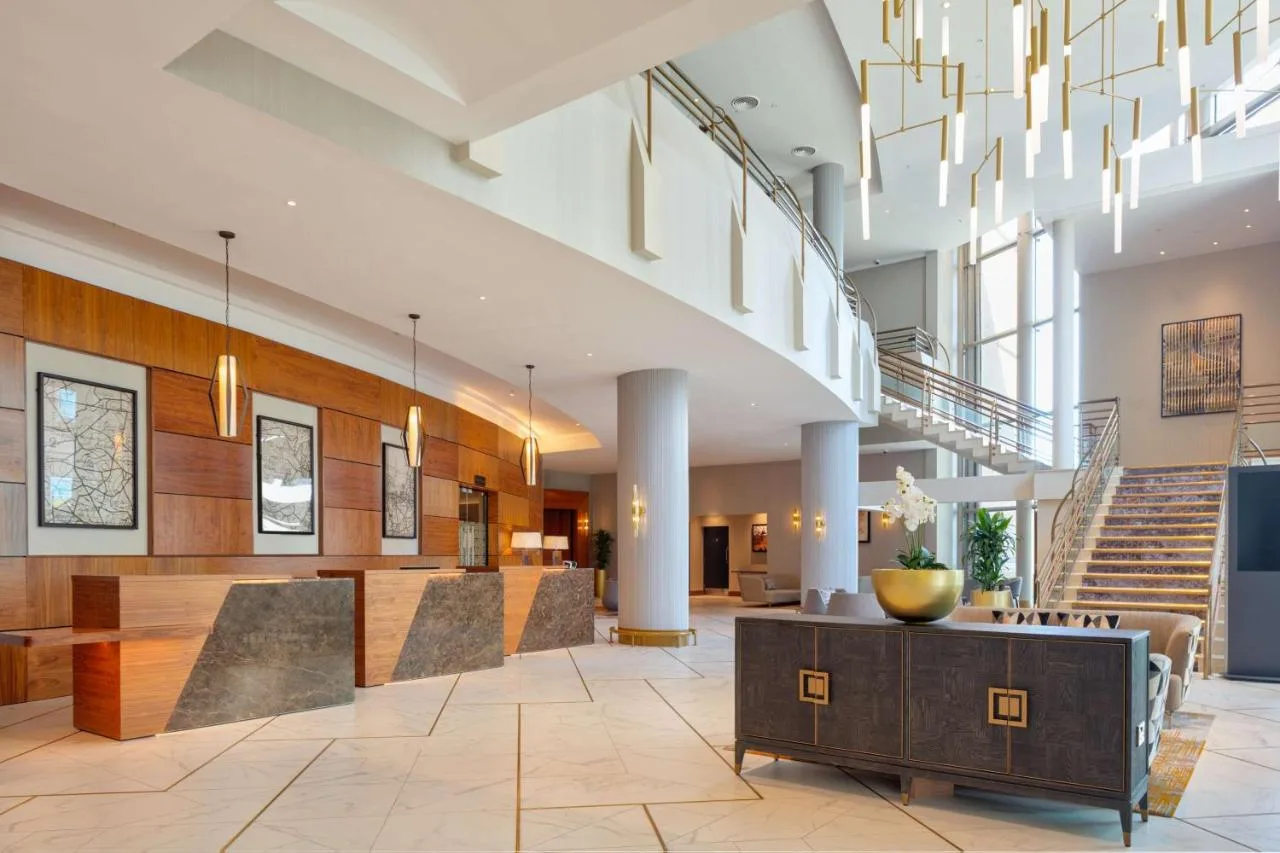 A hotel lobby with a staircase and chandelier at Hilton Belfast on Lanyon Place