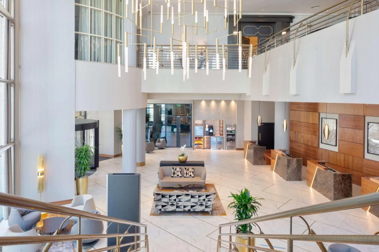A lobby with a couch and chandelier at Hilton Belfast