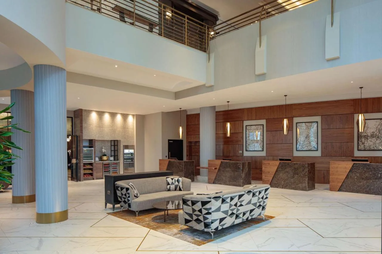 A lobby seating area with a couch and table at Hilton Belfast