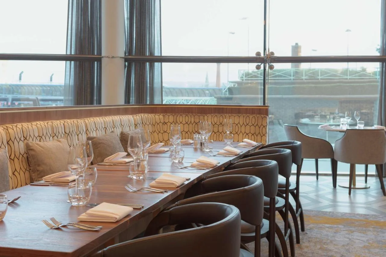 A long dining table set with chairs at Hilton Belfast's restaurant